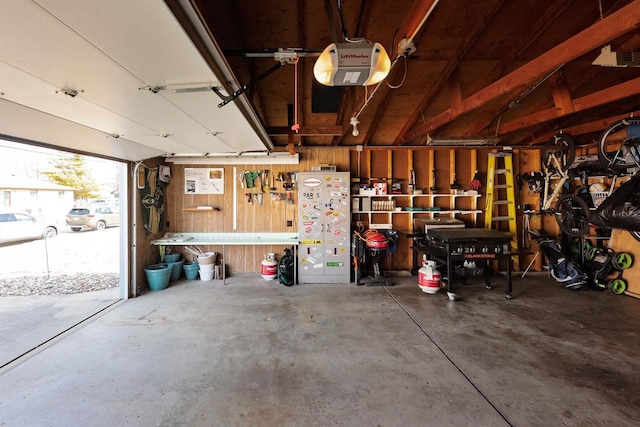 garage with a workshop area and a garage door opener