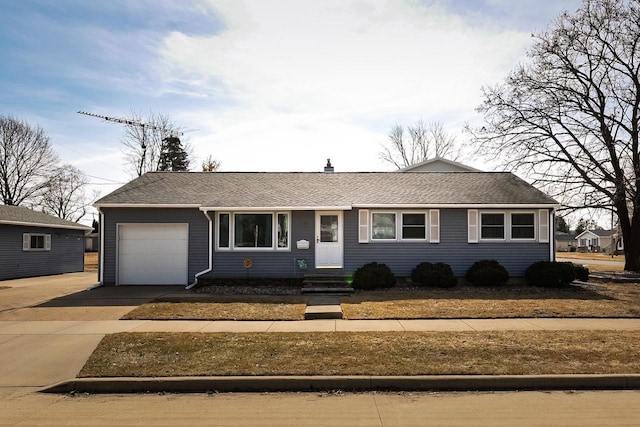 ranch-style house featuring roof with shingles, concrete driveway, and an attached garage