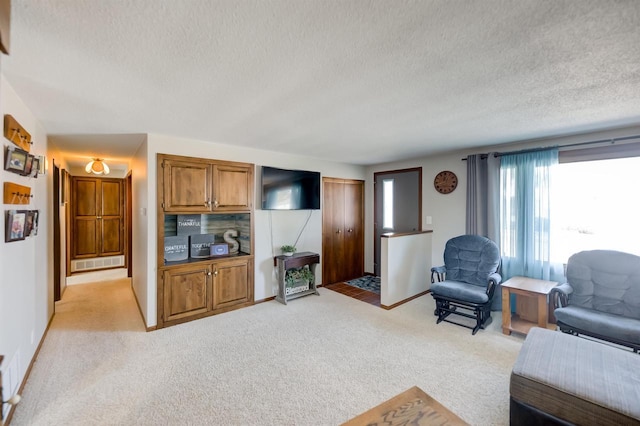 living room with a textured ceiling, baseboards, and light carpet