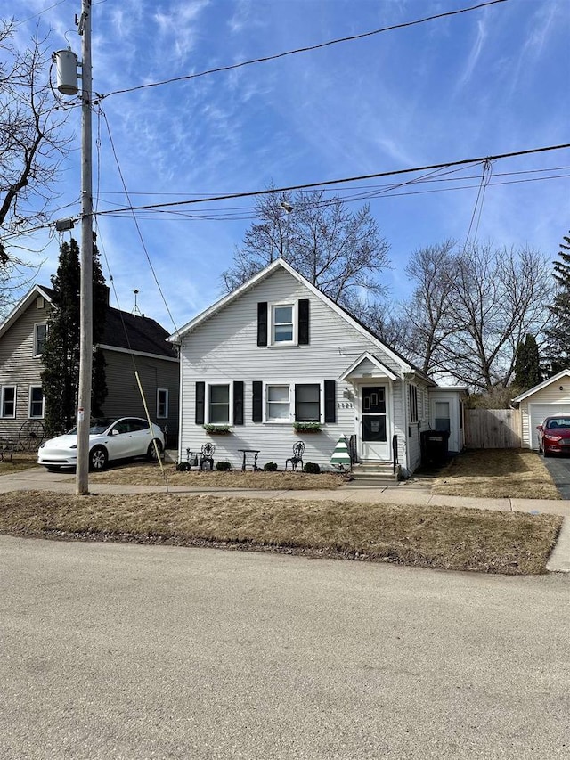 bungalow-style house featuring entry steps, fence, and a garage