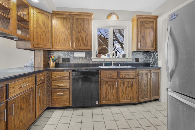 kitchen with light tile patterned flooring, freestanding refrigerator, a sink, black dishwasher, and dark countertops