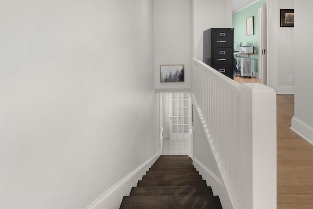 staircase with baseboards and wood finished floors