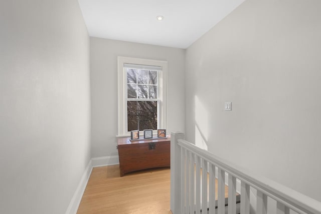 corridor with light wood-style flooring and baseboards