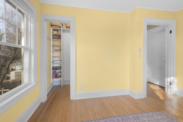 spare room with hardwood / wood-style flooring, baseboards, and ornamental molding