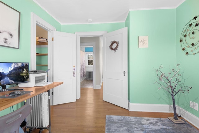 home office with baseboards, wood finished floors, radiator heating unit, and ornamental molding