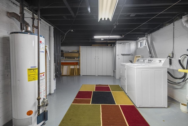 below grade area featuring water heater and washing machine and dryer