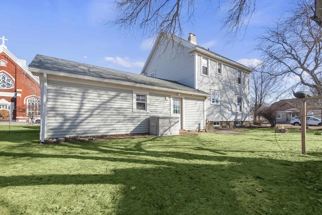 back of house with a yard and a chimney