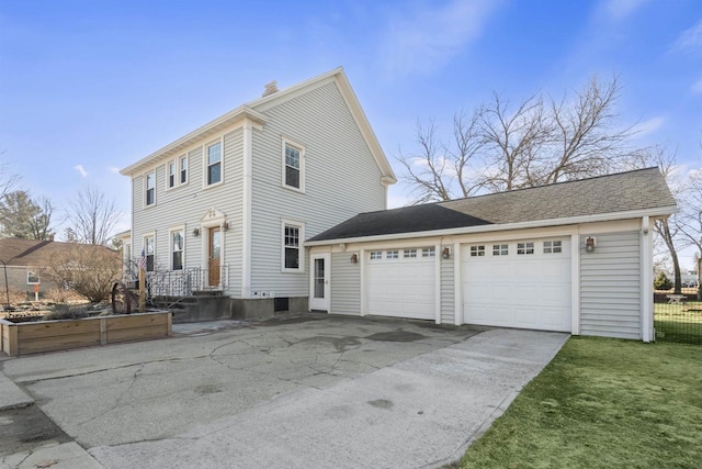 view of front facade featuring concrete driveway, an attached garage, and a chimney