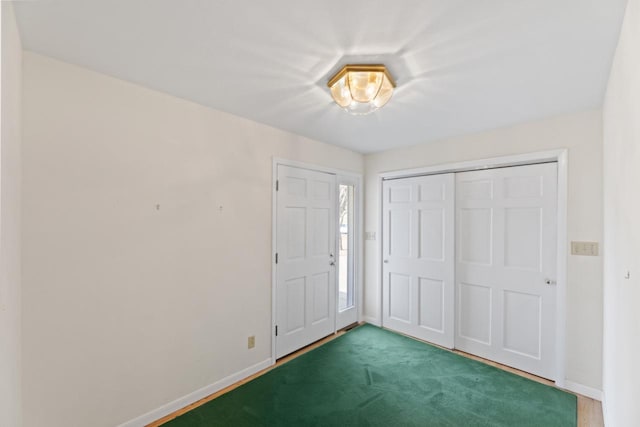 foyer with carpet and baseboards