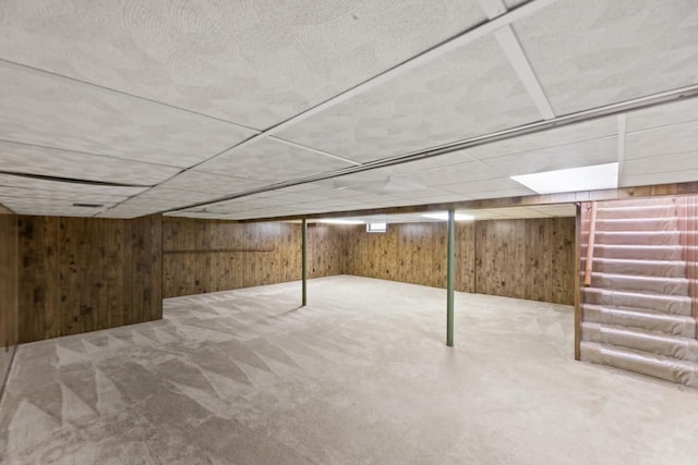 finished basement featuring wooden walls and carpet flooring