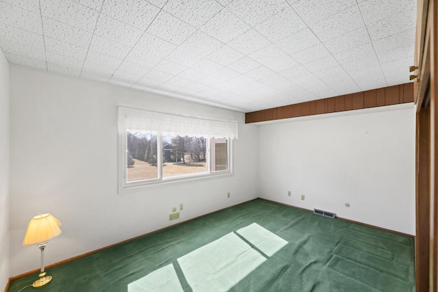 spare room with visible vents, carpet floors, and baseboards