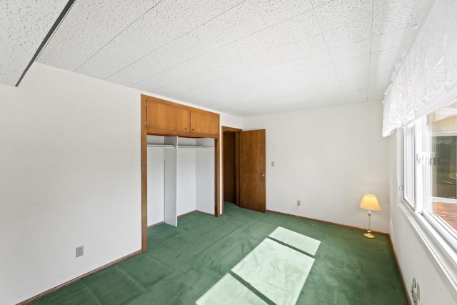 unfurnished bedroom featuring a closet, carpet flooring, and baseboards