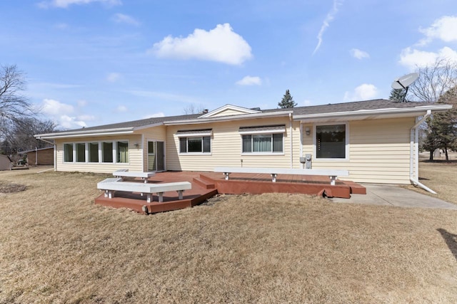 back of property with a deck and a yard