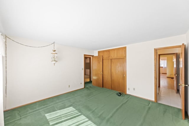 unfurnished bedroom with light carpet, baseboards, and a closet