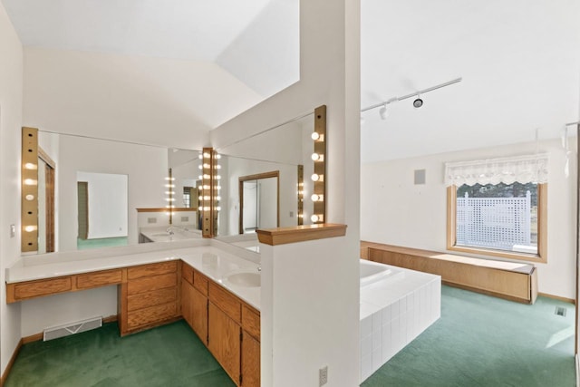 bathroom with visible vents, lofted ceiling, double vanity, a bath, and a sink