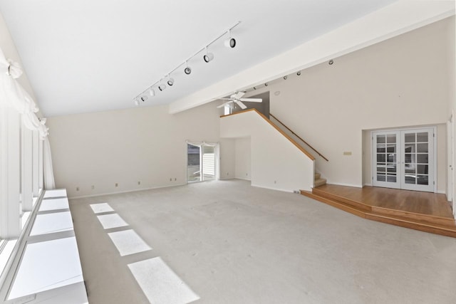 unfurnished living room with beamed ceiling, french doors, carpet floors, stairway, and ceiling fan