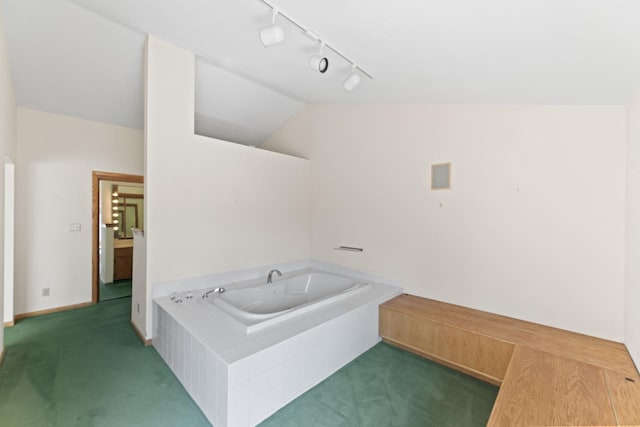 bathroom featuring lofted ceiling and a garden tub