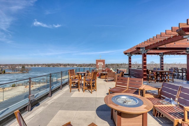 view of patio / terrace with outdoor dining area, a pergola, a water view, and an outdoor fire pit