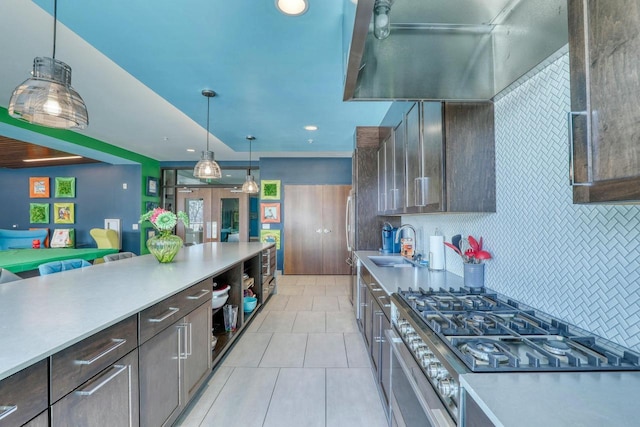 kitchen with a sink, tasteful backsplash, light tile patterned floors, and light countertops