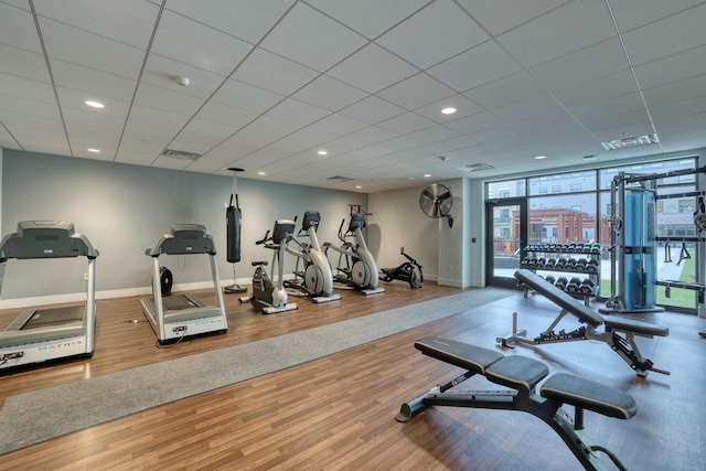 gym featuring visible vents, a wall of windows, baseboards, and wood finished floors