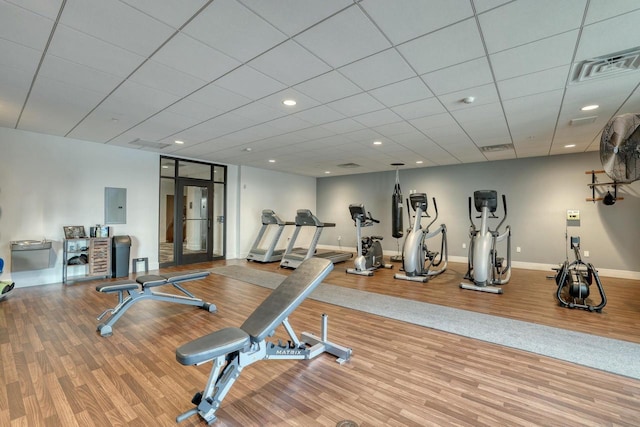 exercise room with visible vents, electric panel, wood finished floors, recessed lighting, and baseboards