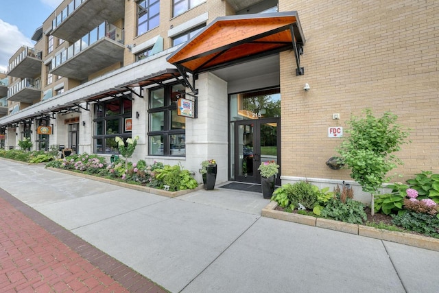 view of exterior entry featuring brick siding