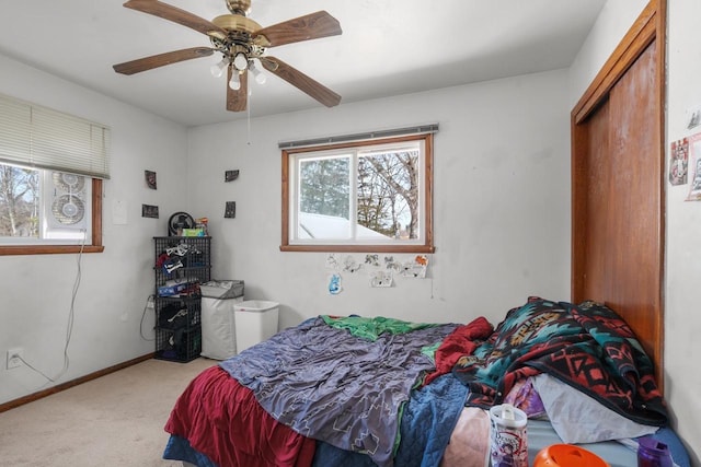 carpeted bedroom with a ceiling fan and baseboards