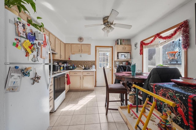 kitchen featuring light brown cabinetry, white appliances, light countertops, and light tile patterned flooring