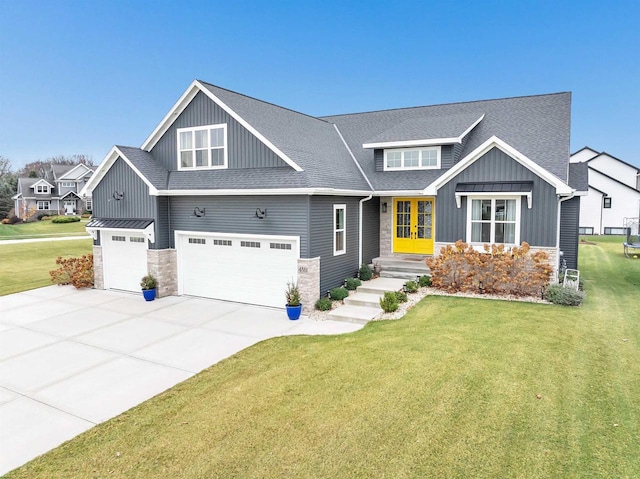 craftsman-style house featuring french doors, board and batten siding, concrete driveway, and a front lawn