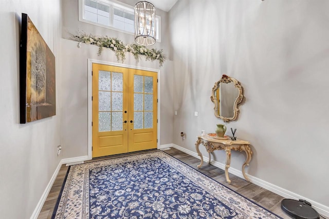 foyer with french doors, baseboards, and wood finished floors