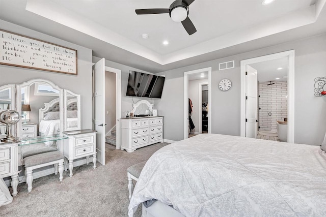 bedroom with a raised ceiling, a spacious closet, carpet, and visible vents