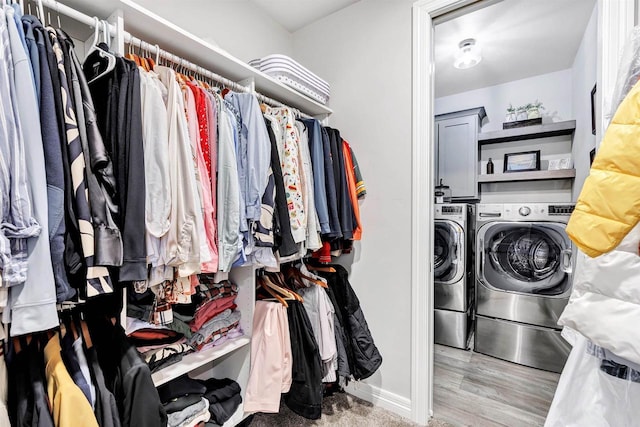 laundry room with washer and dryer, laundry area, and wood finished floors