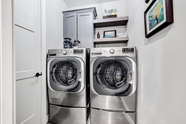 clothes washing area featuring cabinet space and independent washer and dryer