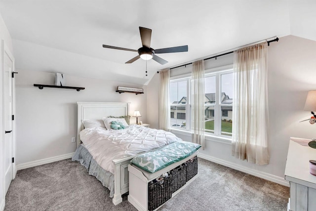 carpeted bedroom featuring baseboards, lofted ceiling, and a ceiling fan