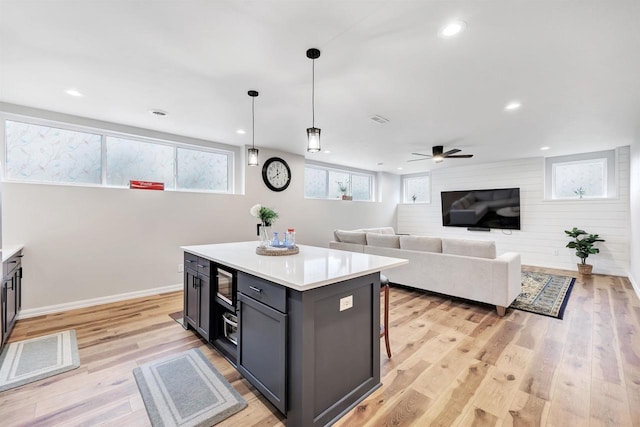 kitchen with a center island, light countertops, light wood-type flooring, recessed lighting, and a ceiling fan