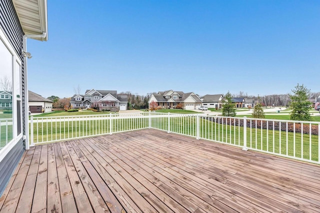 wooden terrace featuring a lawn and a residential view