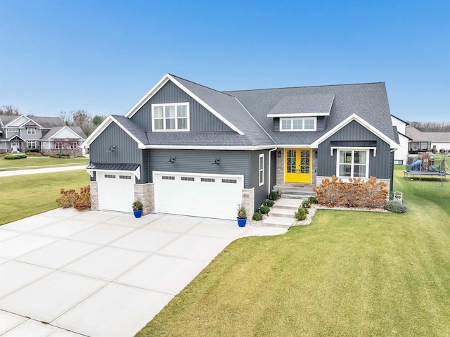 craftsman inspired home featuring stone siding, a trampoline, board and batten siding, and a front lawn