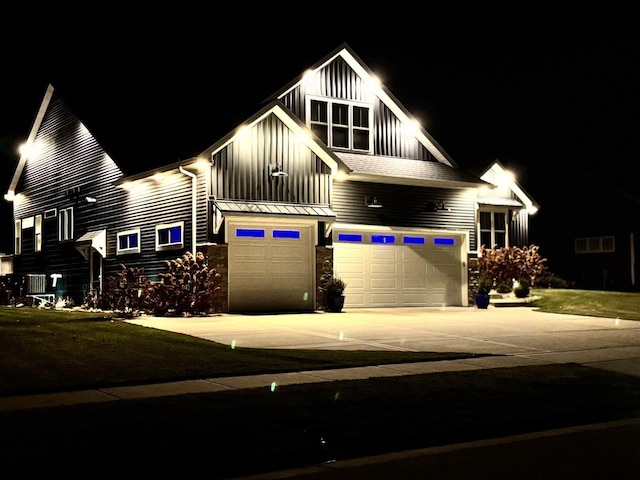 view of front of house with a garage, stone siding, board and batten siding, and driveway