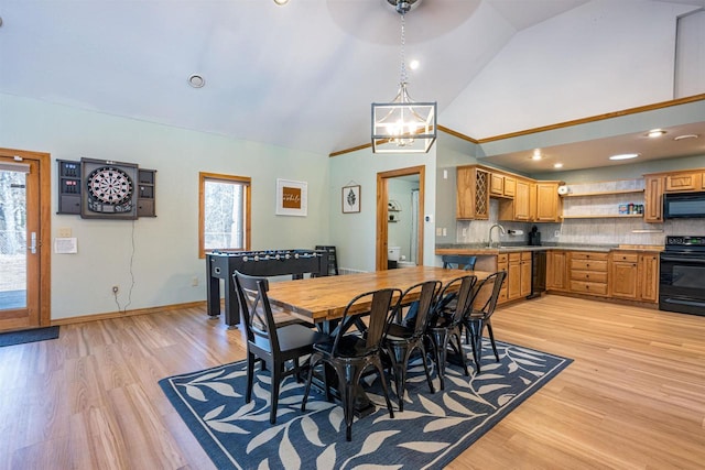 dining area with high vaulted ceiling, light wood-style flooring, baseboards, and an inviting chandelier