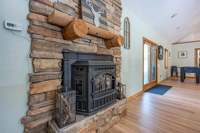 interior details with french doors, a wood stove, baseboards, and wood finished floors