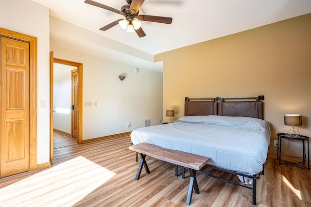 bedroom with baseboards, a ceiling fan, and light wood finished floors