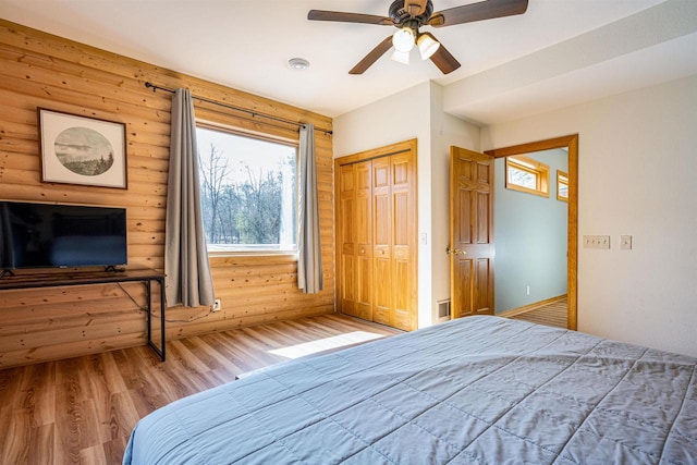 unfurnished bedroom with a ceiling fan, wood finished floors, and a closet