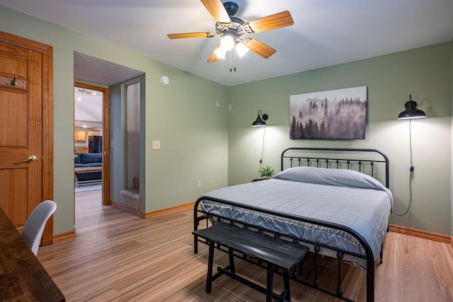 bedroom with light wood-style flooring, a ceiling fan, and baseboards