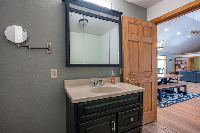 bathroom featuring vanity, wood finished floors, and a textured wall