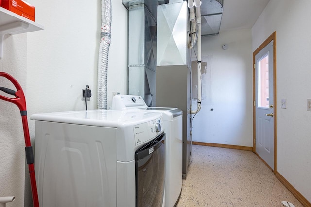 washroom featuring washer and dryer, laundry area, and baseboards