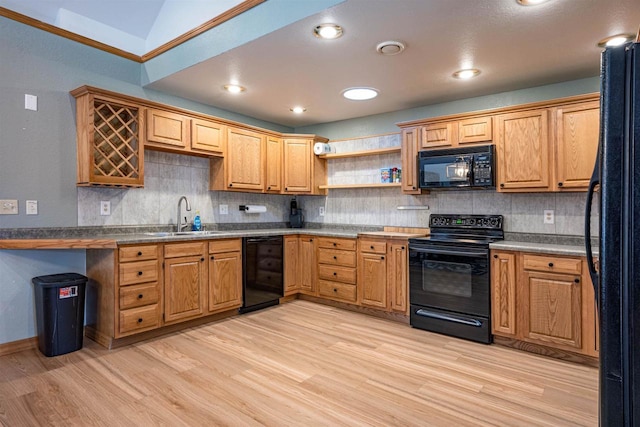 kitchen featuring black appliances, light wood-type flooring, backsplash, and a sink