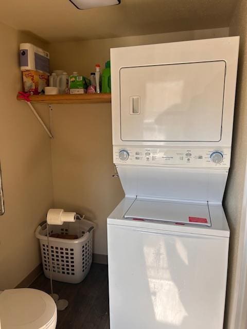 clothes washing area with stacked washer / dryer, laundry area, and wood finished floors