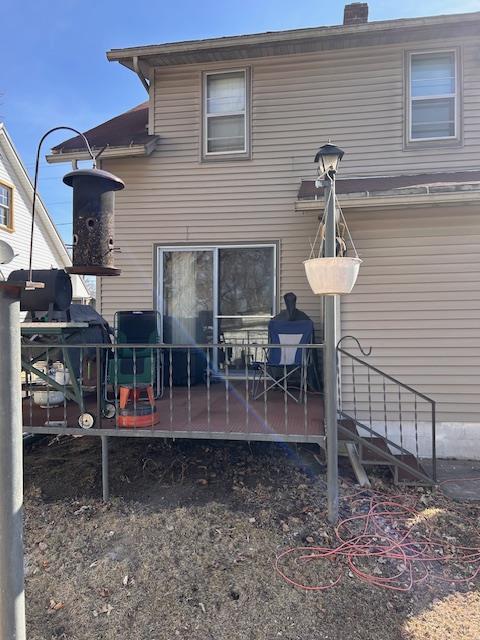 back of property with a wooden deck and a chimney