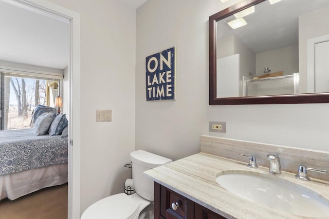 full bathroom featuring vanity, toilet, a shower with shower door, and connected bathroom