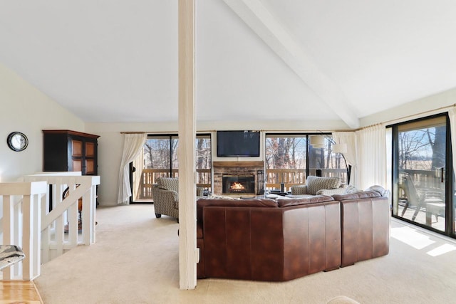 living room featuring a wealth of natural light, carpet flooring, and vaulted ceiling with beams